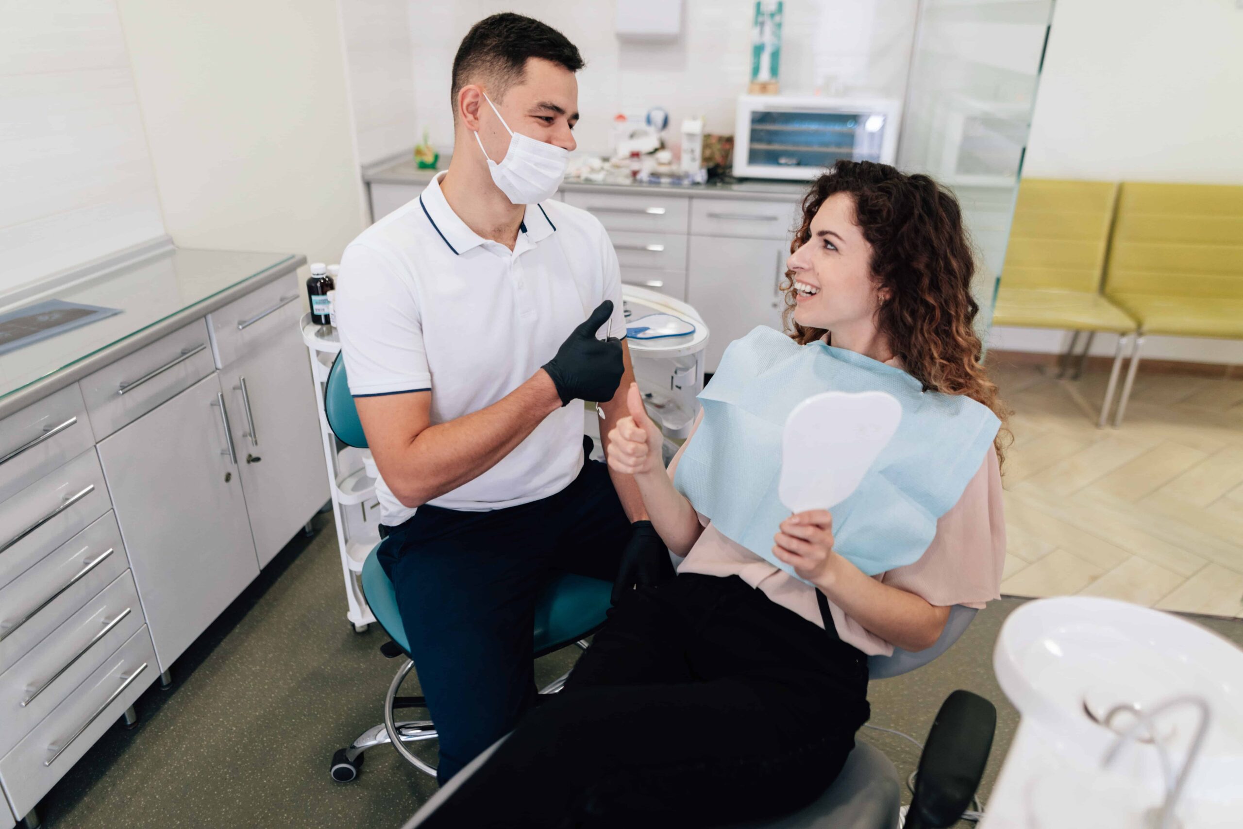 dentista com paciente sentados em caideras em consultório odontológico 